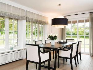 a dining room with a table and chairs and windows at Landhaus-Mare in Kampen