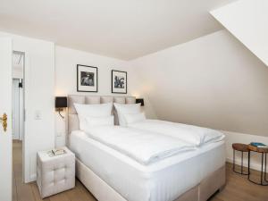 a white bedroom with a large white bed at Landhaus-Mare in Kampen