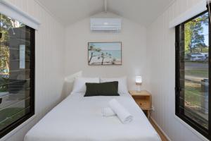 a small bedroom with a bed and a window at Reflections Moonee Beach - Holiday Park in Moonee Beach