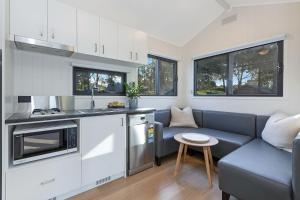 a living room with a couch and a kitchen at Reflections Moonee Beach - Holiday Park in Moonee Beach