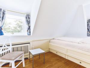 ein Schlafzimmer mit einem Bett, einem Stuhl und einem Fenster in der Unterkunft Wattgarten in Kampen