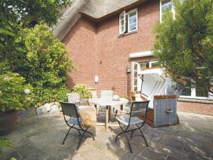 a patio with a table and chairs in front of a brick building at Wattenhof-3 in Kampen