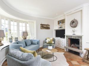 a living room with a blue couch and a fireplace at Hortensienhues-West in Kampen