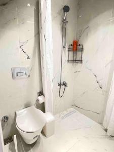 uma casa de banho branca com um WC e um chuveiro em Akbay Home Bozcaada mini. Denize 500 mt em Bozcaada