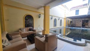 a living room with couches and a swimming pool at RedDoorz Syariah At Demasto Homestay Jember in Jember
