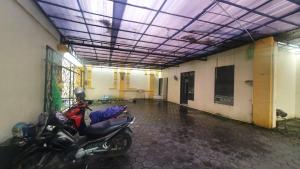 a room with a motorcycle parked in a building at RedDoorz Syariah At Demasto Homestay Jember in Jember