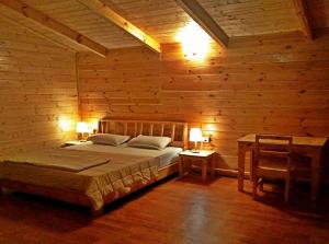 a bedroom with a bed and a desk with two lamps at LABDHI RESORTS Stag Groups not allowed in Masinagudi