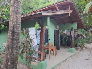 ein kleines Haus mit einem Tisch und einem Holzdach in der Unterkunft Casa Rosada Nosara in Nosara