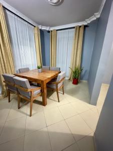 a dining room with a wooden table and chairs at Sally's home-near JNIA airport in Dar es Salaam