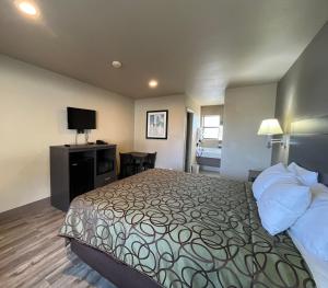 a hotel room with a bed and a desk at Mountain View Inn in Flagstaff