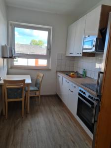 une petite cuisine avec une table et une fenêtre dans l'établissement Wohnung in Herne, à Herne