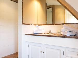 uma casa de banho com um lavatório e um espelho em Prahl-Hues-2 em Kampen