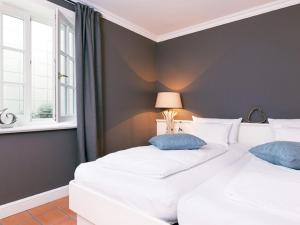 Duas camas brancas num quarto com uma janela em Prahl-Hues-2 em Kampen
