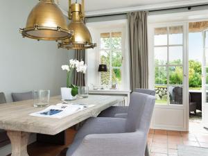 a dining room with a table and chairs and windows at Prahl-Hues-3 in Kampen