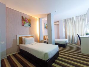 um quarto de hotel com uma cama grande num quarto em First Residence Hotel by RVH em Cukai