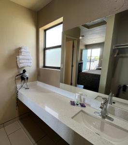 łazienka z umywalką, lustrem i łóżkiem w obiekcie Mountain View Inn w mieście Flagstaff