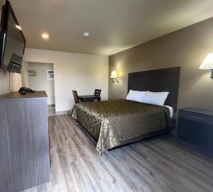 Mountain View Inn في فلاغستاف: غرفة فندقية بسرير وتلفزيون بشاشة مسطحة