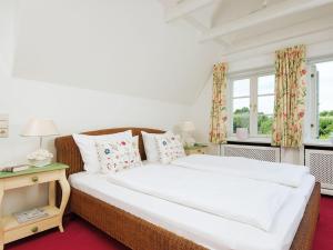 a bedroom with a large bed and two windows at Haus-Werner in Kampen