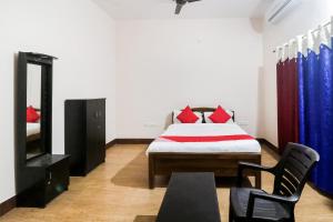 a bedroom with a bed and a chair in it at OYO Flagship 64921 Purple Villa in Bhubaneshwar