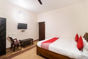 a bedroom with a bed and a tv on the wall at OYO Flagship 64921 Purple Villa in Bhubaneshwar