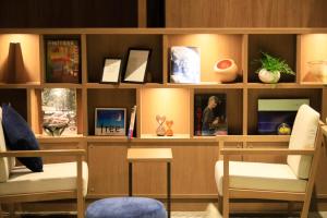 un estante de libros con dos sillas y fotos en él en Naruko Fuga en Osaki