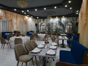 a dining room with tables and chairs and a room with tables and chairsktop at BANQUETING & GUEST HOUSE ПОМЕСТЬЕ in Kostanay