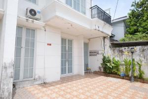 Cette maison blanche dispose d'une terrasse. dans l'établissement RedDoorz at Golden White House Pettarani, à Makassar