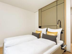 two beds in a hotel room with white and yellow pillows at Ferienwohnung-K6 in Kampen