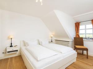 a white bed in a room with a window at Haus-Peter in Kampen
