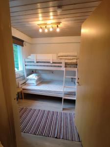 a small room with a bunk bed and a window at Maggala apartments in Utsjoki