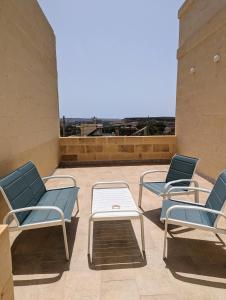 a group of chairs and a table on a roof at Sea Holly Gozo in Nadur