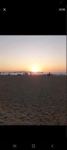 - un coucher de soleil sur une plage de sable avec l'océan dans l'établissement kusadası, davutlar mah. 1+1 mobilyalı site içinde yazlık daire, à Kusadası