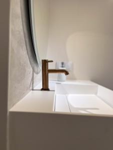 a bathroom sink with a gold faucet at Apartament Grossa w stylu Japandi - Dream Apart in Bielsko-Biała