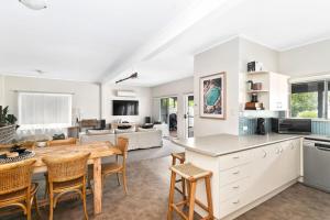 Una cocina y una sala de estar con mesa y sillas. en Pacifica, en Mollymook 14 fotos más