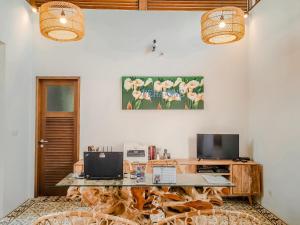 a room with a desk with a computer and a television at Pera ONE Villas in Gili Trawangan