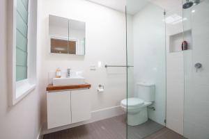 Un baño con inodoro y ducha de cristal. en Relaxed Coastal Retreat, en Mollymook 7 fotos más