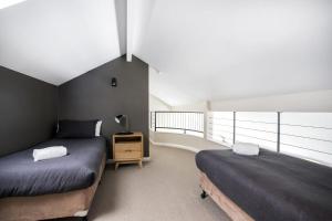 a bedroom with two beds and a night stand in a room at Surfers Reef Escape Mollymook in Mollymook