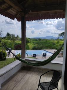 a hammock on a porch with a view of a pool at Encanto cafetero quimbaya in Quimbaya