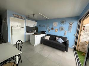 sala de estar con sofá y cocina en Appartement Valras 1ere ligne vue mer en Valras-Plage