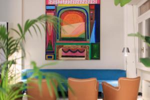 a room with chairs and a painting on the wall at La Serena Hotel FDM in Forte dei Marmi