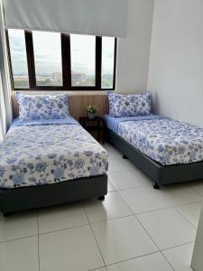 two beds sitting next to each other in a room with windows at PadiViu Family Suite at Imperio Professional Suite, Alor Setar in Alor Setar