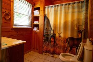 a bathroom with a shower curtain with a picture of a deer at Smoky Waters Chalet in Sevierville +32 photos