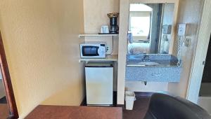 uma pequena cozinha com um micro-ondas e um lavatório em Apollo Lodge and RV Park em Fairfield