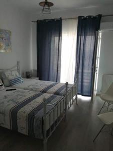 1 dormitorio con 1 cama grande y cortinas azules en Tina Guest House en Basarabi