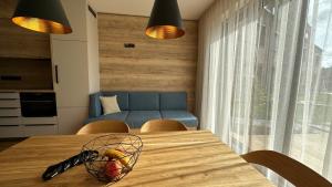 a dining room table with a bowl of fruit on it at LAKE SIDE apartmán SEASCAPE - Černá v Pošumaví in Černá v Pošumaví