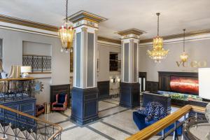 a lobby of a building with columns and a fireplace at voco The Tiger Hotel, Columbia, MO, an IHG Hotel in Columbia