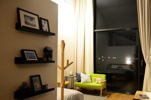 ein Wohnzimmer mit einem grünen Stuhl und ein Schlafzimmer in der Unterkunft Jeju Claire de lune in Jeju-do