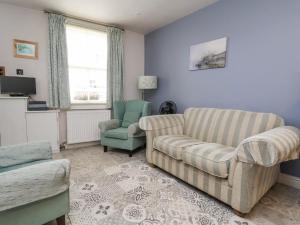 a living room with a couch and a chair at Millgate Cottage in Conwy