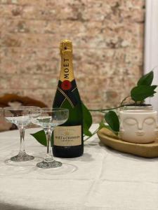 a bottle of champagne and two glasses on a table at Hazel House Goulburn in Goulburn