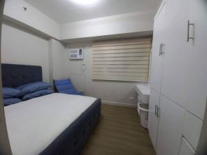 Dormitorio pequeño con cama y lavamanos en Lovely 1 bedroom at Vista Shaw Residences, en Manila